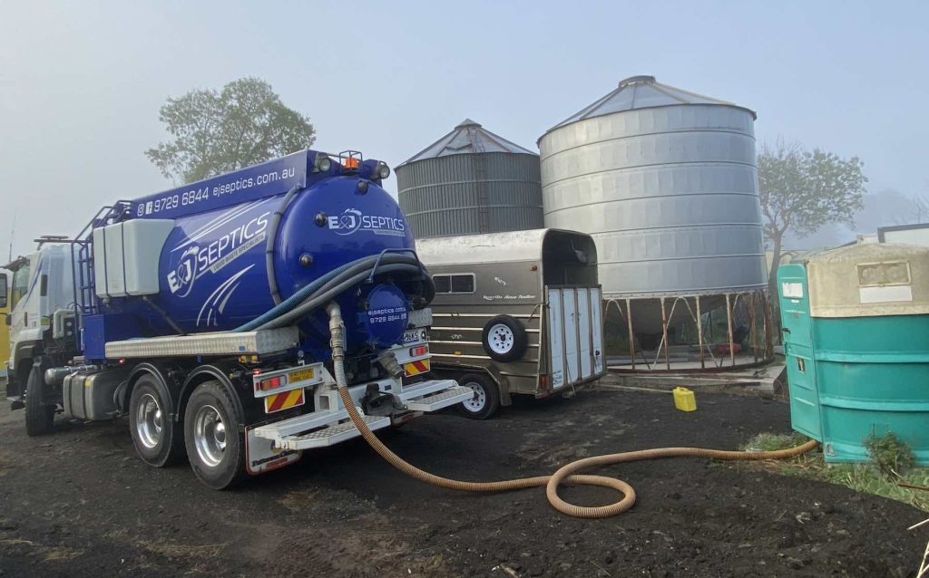 Septic truck pumping wastewater from septic tanks on a rural Warragul property.