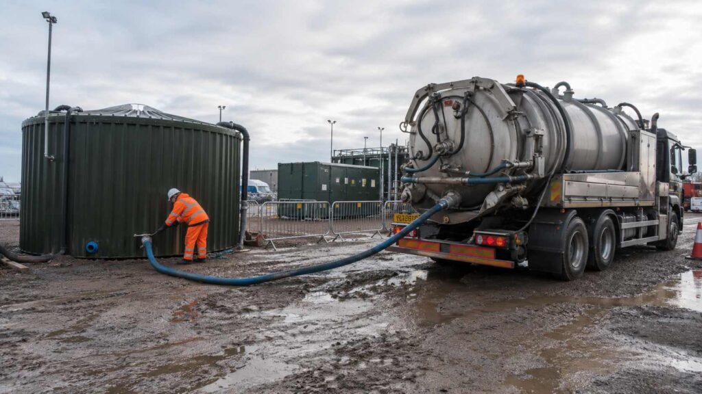 Vacuum tanker removing liquid waste from a commercial
