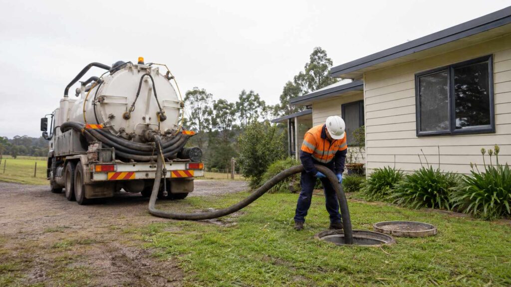 Septic technician pumping out a residential septic tank using a